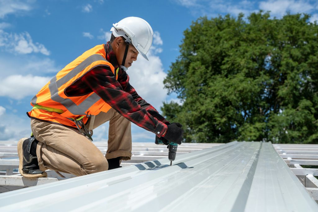 Takläggare arbetar och installerar ny takkonstruktion på husets översta tak.